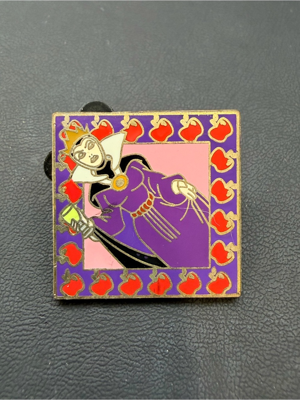 Disney evil Queen Grimhilde pin with a purple boarder with red apples